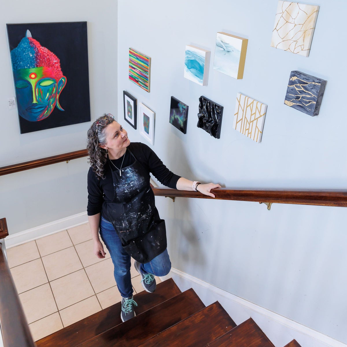Person standing on a staircase looking at wall art