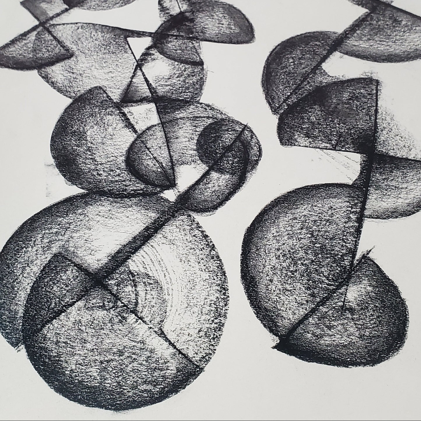 A piece of abstract art drawing with charcoal on paper, featuring circular and curved shapes.