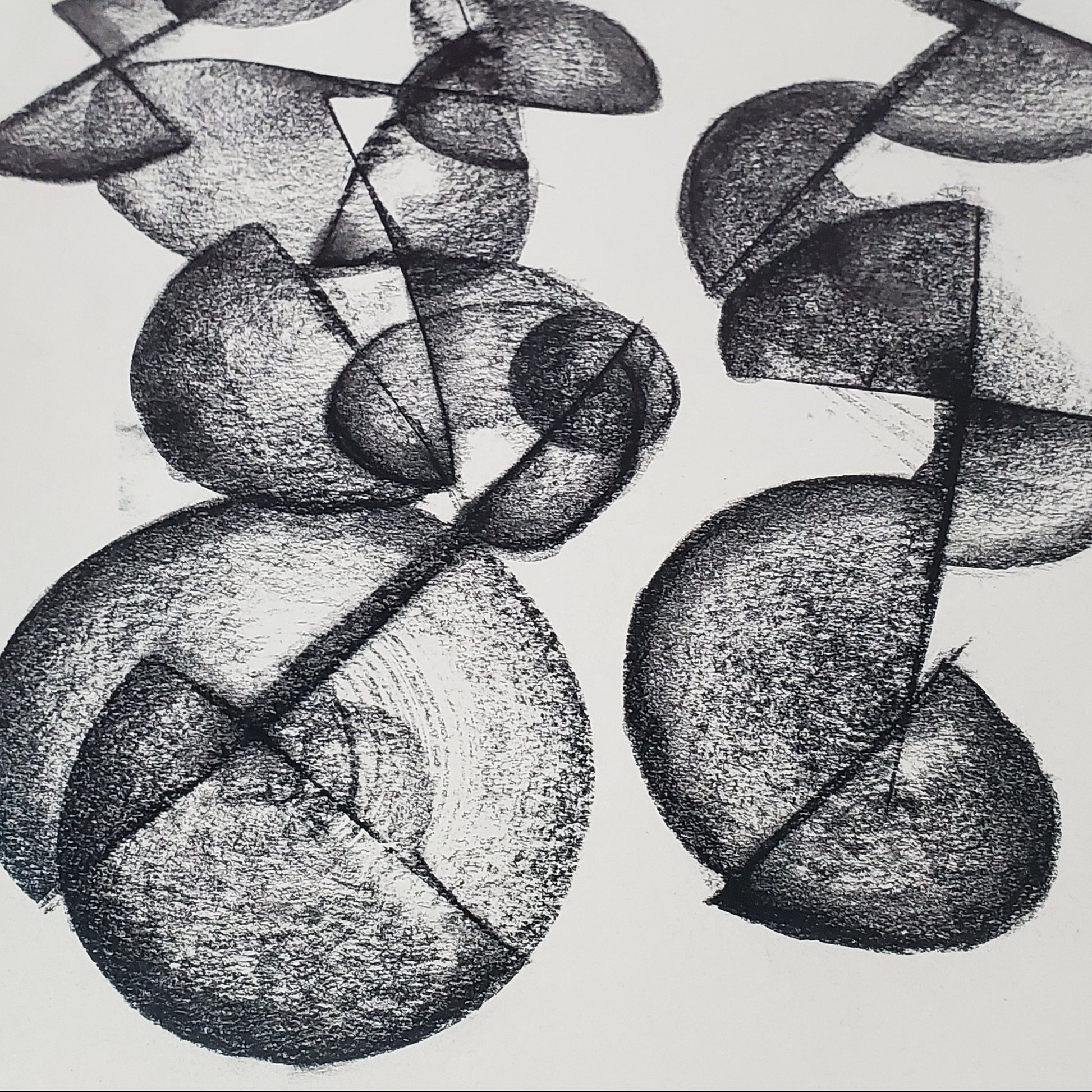 A piece of abstract art drawing with charcoal on paper, featuring circular and curved shapes.