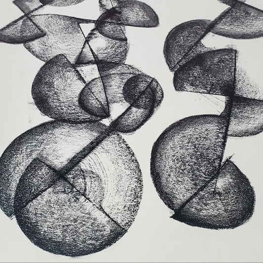 A piece of abstract art drawing with charcoal on paper, featuring circular and curved shapes.