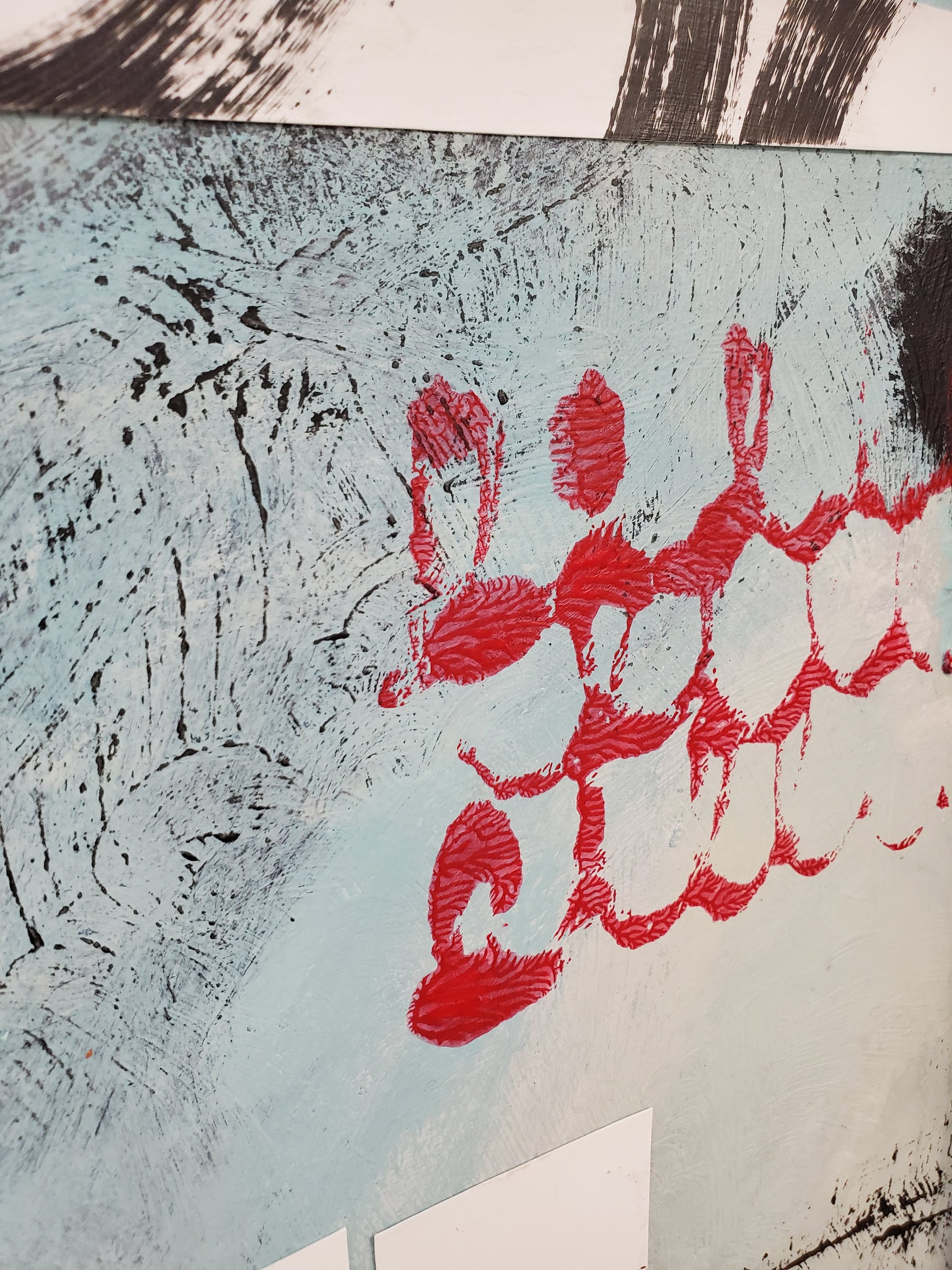 Abstract artwork with red loop design on a textured surface