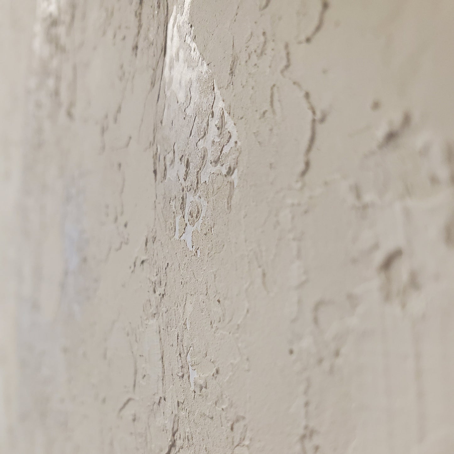 Close-up of a textured beige wall with a small crack.