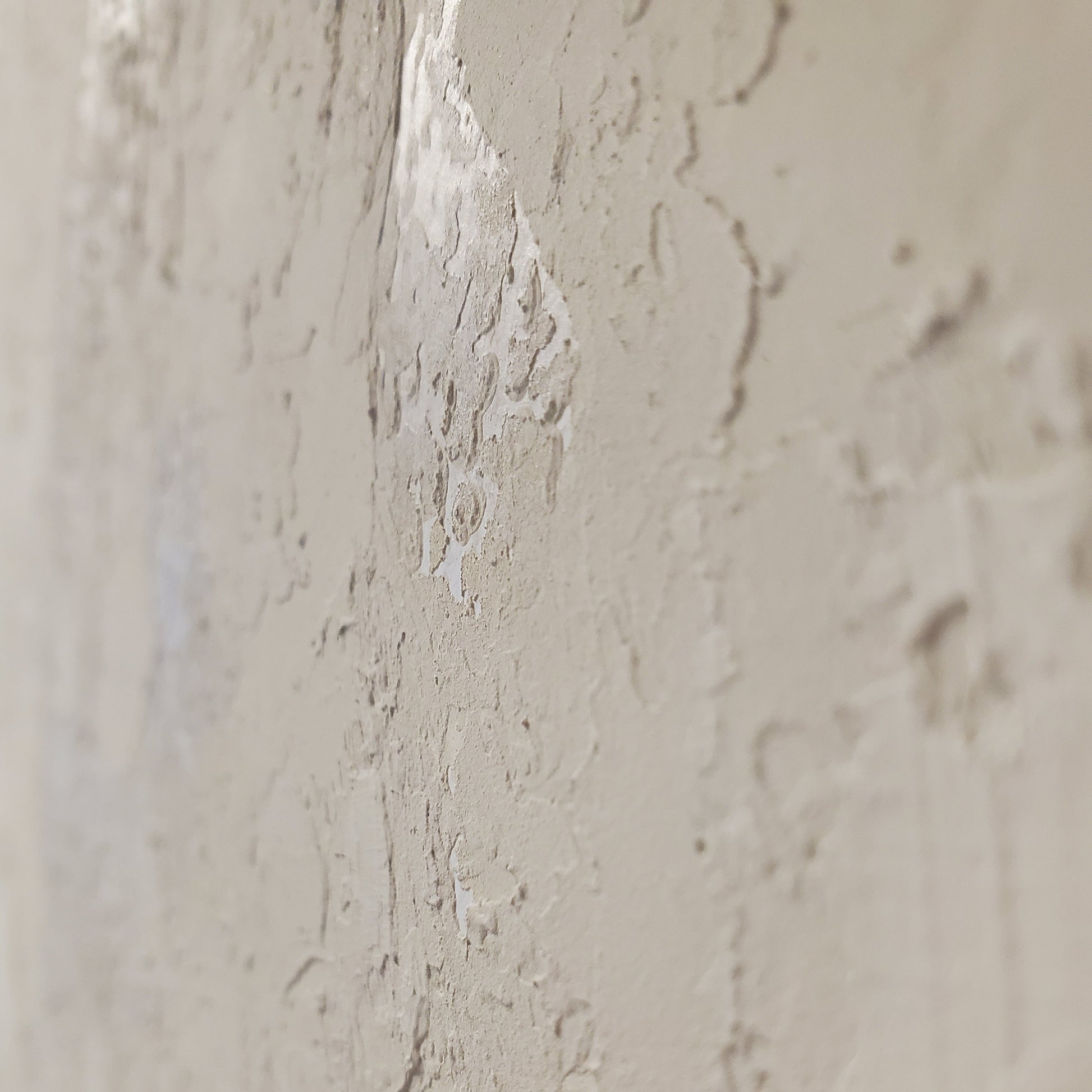 Close-up of a textured beige wall with a small crack.