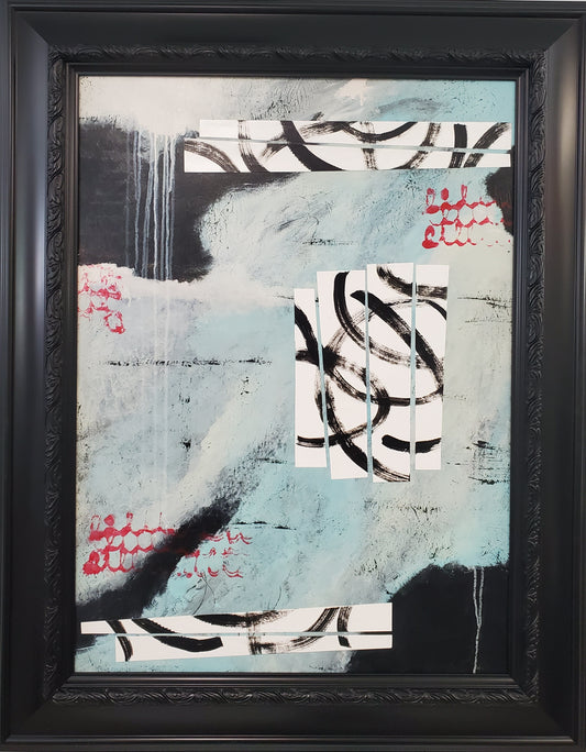 Abstract art piece in a black frame on a light gray wall